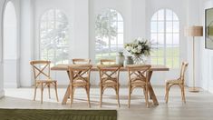 a dining room table with four chairs and a vase filled with flowers on top of it