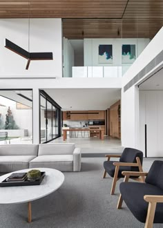 a living room filled with furniture next to a large open floor plan on top of a wooden ceiling