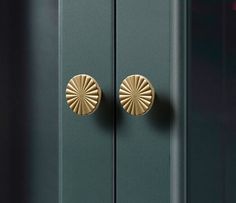 a green cabinet with two gold knobs on it