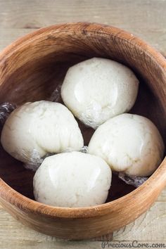 four dumplings in a wooden bowl on a table