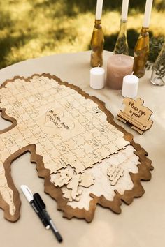 a wooden puzzle is sitting on a table with candles and other items around it,