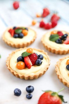 small fruit tarts are arranged on a table