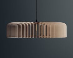 a wooden light fixture hanging from a black ceiling with grey walls in the back ground