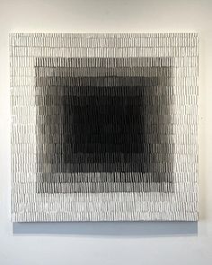 an abstract black and white painting hanging on a wall