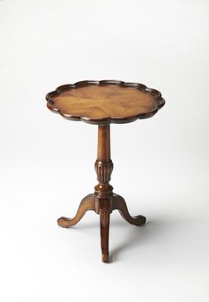 an antique wooden table with carved legs and a tray on the top that has been turned upside down