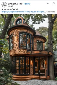 an unusual house built in the middle of a tree lined area with lots of windows