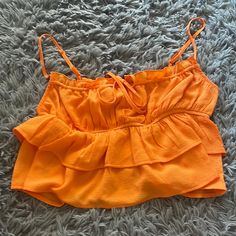 Wild Fable/ Orange Ruffle Crop Top Never Worn It Never Fit Me Right Looks A Lot Better On A Smaller Chest Btw All Straps Are Adjustable And The Tie In The Front Brand New Condition Super Cute For Summer, Love Make An Offer! Flirty Ruffled Crop Top For Brunch, Tiered Ruffle Hem Top For Vacation, Chic Ruffled Crop Top For Vacation, Orange Sleeveless Ruffled Top, Orange Ruffled Tops For Vacation, Orange Ruffled Top For The Beach, Orange Ruffled Top For Beach, Spring Vacation Crop Top With Ruffles, Vacation Ruffle Crop Top