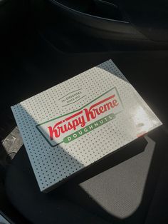 a krispy kreme box sitting on the back seat of a car