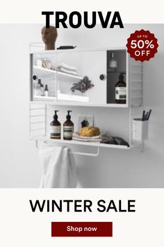 a white shelf with some bottles and soaps on it next to a towel rack