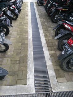 rows of motorcycles are lined up on the sidewalk