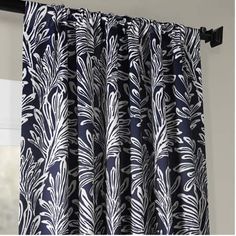 the curtains are hanging in front of a window with black and white designs on it