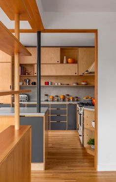 an open kitchen with wooden cabinets and counter tops, along with hardwood flooring that matches the walls