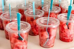 plastic cups with strawberries in them are lined up on a table and ready to be eaten