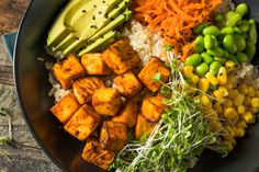 a bowl filled with rice, vegetables and tofu