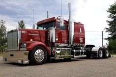 a red semi truck parked in a parking lot