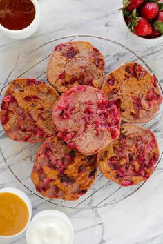 strawberry muffins on a glass plate next to bowls of fruit