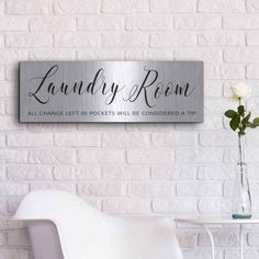 a white chair in front of a brick wall with a sign that says laundry room