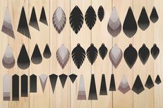 an array of black and white designs on wooden planks, with one being cut out to look like feathers