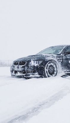 a car is parked on the side of the road covered in snow