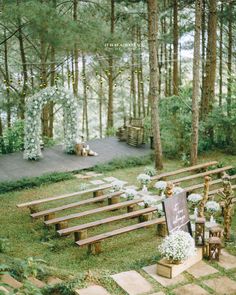 an outdoor ceremony setup with wooden benches and flowers