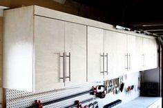 an organized garage with pegboard and cabinets