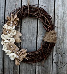 an image of a wreath with flowers on the front and side of it, which is attached to a wooden fence