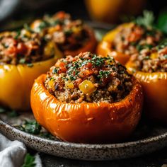 stuffed bell peppers with meat and vegetables on a plate, ready to be served in the oven