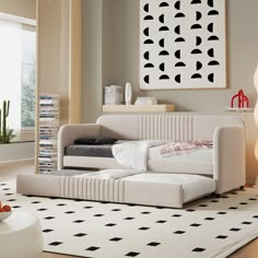 a white couch sitting on top of a rug in a living room