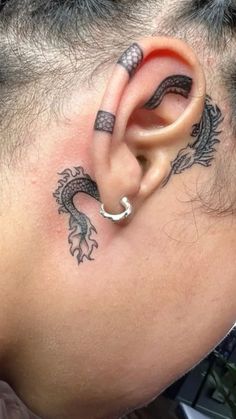 a person with a dragon tattoo on their ear