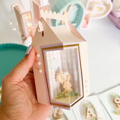 a person holding up a small box with a little fairy on it's side