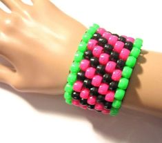 Neon Green, Hot Pink and Black Kandi Cuff  The kandi bracelet contains seven layers of neon green, hot pink and black in a diagonal pattern. It is made with stretch cord. The kandi cuff fits up to a 6.5-7in. wrist. Size adjustment is free. Please send a convo if size adjustment is needed.  It's super fun and great for kandi ravers.  Check out more of my kandi cuffs here: http://www.etsy.com/shop/Allysin?section_id=5622824  Have a look at my other shops: supplies: http://plurfection.etsy.com Uniq Rave Jewelry, Kandi Necklace, Kandi Cuff, Kandi Patterns