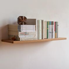 a book shelf filled with books on top of a white wall