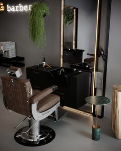 a barber chair sitting in front of a mirror next to a table with a plant on it