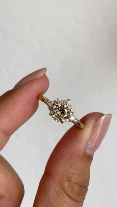 a woman's hand holding an old diamond ring