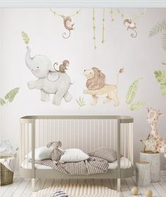 a baby's room with an elephant, giraffe and monkey wall decals