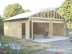 an image of a garage being built in the yard with lawn chairs and tables around it