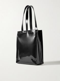 Acne Studios' tote bag is made from faux glossed-leather in a tall, structured profile. It's embossed with the logo across the front and opens to a twill-lined interior with a slim pocket for easy access to your phone or wallet. Black Leather Shoulder Bag With Glossy Finish, Sleek Black Glossy Shoulder Bag, Elegant Glossy Finish Tote Bag, Classic Glossy Travel Bag, Classic Leather Bag With Glossy Finish, Designer Leather Bag With Glossy Finish, Classic Leather Shoulder Bag With Glossy Finish, Top Handle Shoulder Bag With Glossy Finish For Shopping, Top Handle Bags With Glossy Finish For Shopping