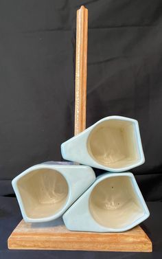 three bowls are stacked on top of each other in front of a black background with a wooden stick sticking out of it