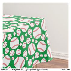 a green and white tablecloth with baseballs on it in the middle of a room