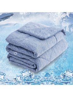 three blankets stacked on top of each other in front of an ice covered background with snow flakes