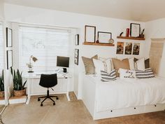 a bedroom with a bed, desk and computer on top of the dresser next to it