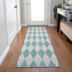 a blue and white rug on the floor in front of a door with a bench