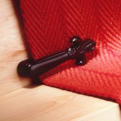 a close up of a red piece of cloth with a black handle on the end