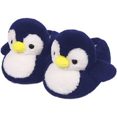 two blue and white stuffed animals sitting next to each other on a white surface with one penguin facing the camera