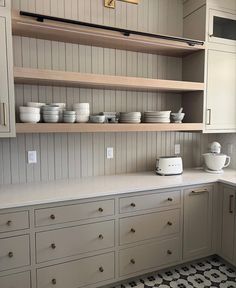 the kitchen is clean and ready to be used for cooking or baking, with dishes on the shelves