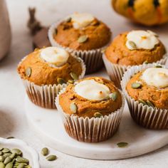 pumpkin spice muffins with cream cheese frosting and pumpkin seeds on the side