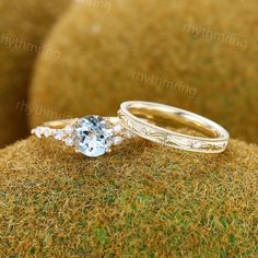 two wedding rings sitting on top of a moss covered surface