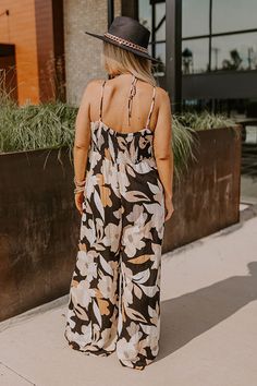 - Kick back and enjoy some vacay vibes in this stylish jumpsuit! - Unlined material with an abstract floral print - A v-cut neckline with a twist detail - Adjustable spaghetti straps - A smocked upper back with a tie detail - A wide legged jumpsuit with floor length hemlines Chic Printed Jumpsuits And Rompers For Vacation, Chic Printed Jumpsuit For Vacation, Chic Tropical Print Jumpsuits And Rompers For Vacation, Chic Tropical Print Jumpsuit For Vacation, Black Printed Jumpsuits And Rompers For Beach, Black Printed Jumpsuit For Beach, Chic Floral Print Jumpsuits And Rompers For Beach, Chic Floral Print Beach Jumpsuit, Chic Beach Jumpsuit With Floral Print