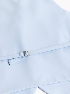 a close up of a blue shirt with a metal buckle on the front and side