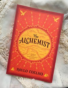 the alchemist by julia collio on top of a white lace covered bed